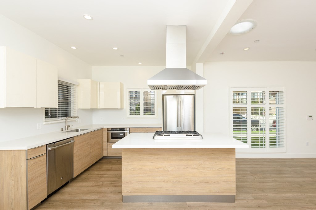a large white kitchen with wooden cabinets and a white counter top