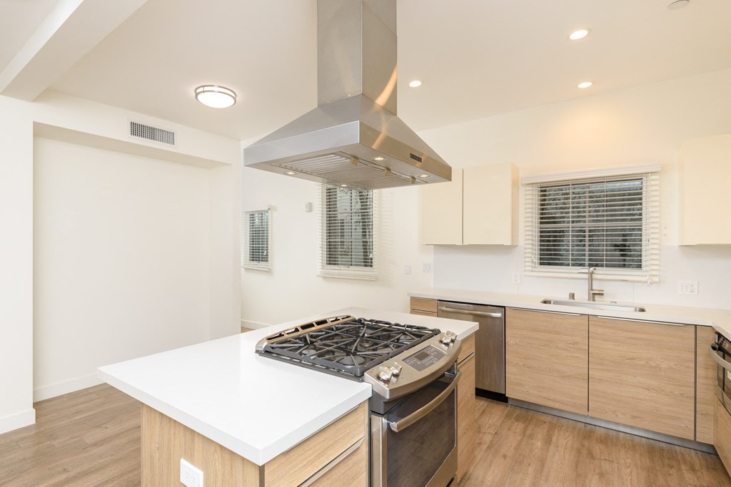 a kitchen with white counter tops and a stove top oven
