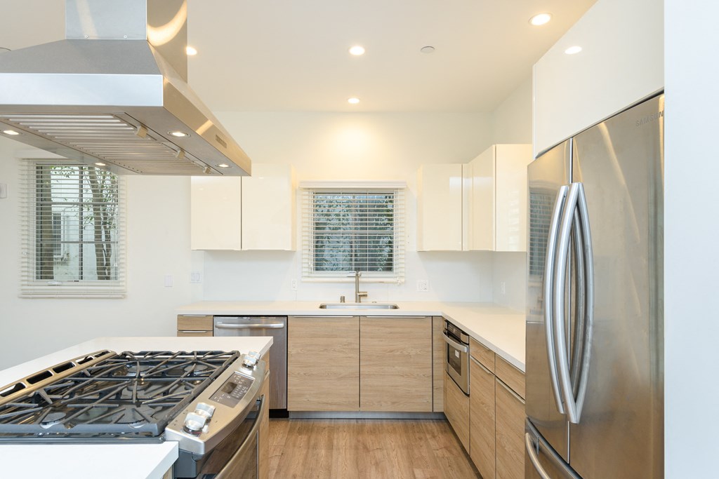 a kitchen with white countertops and stainless steel appliances