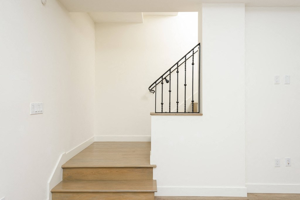 a staircase in a home with white walls and wooden stairs
