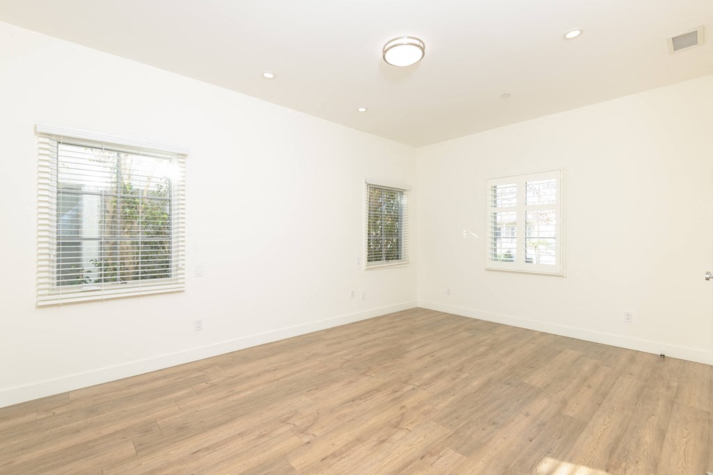 an empty living room with white walls and wood floors