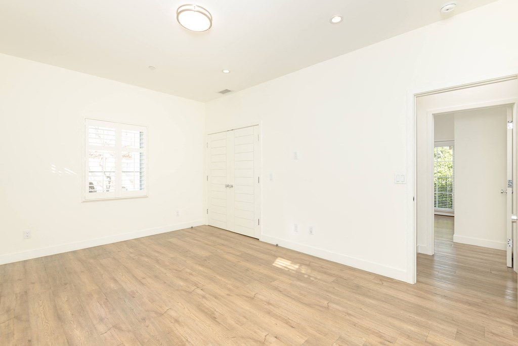 a living room with a hardwood floor and white walls