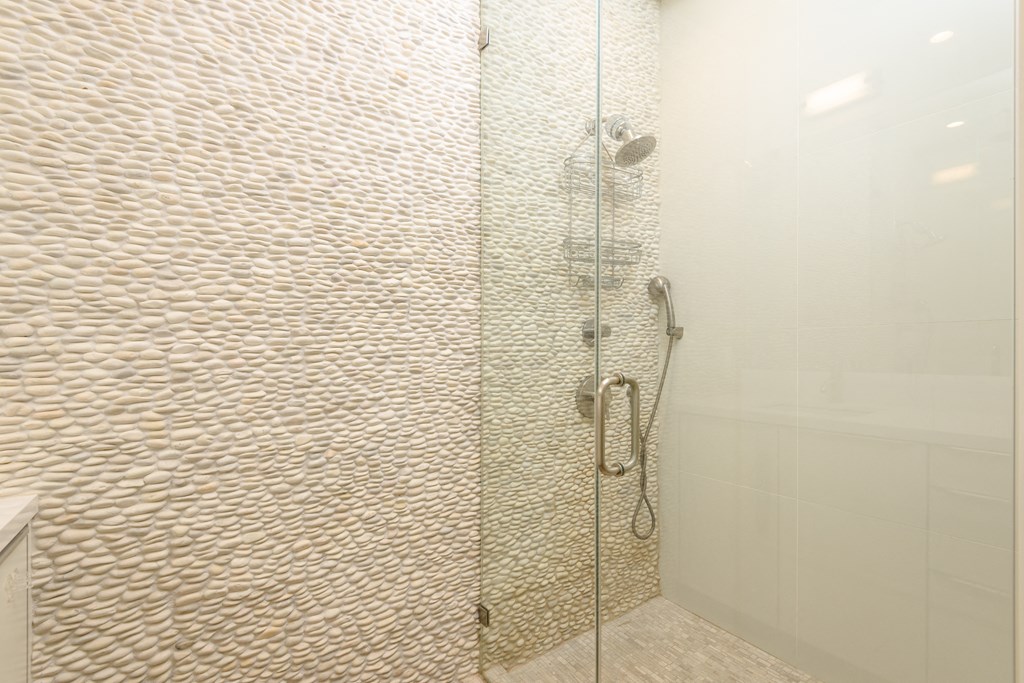 a large shower with a glass door in a bathroom