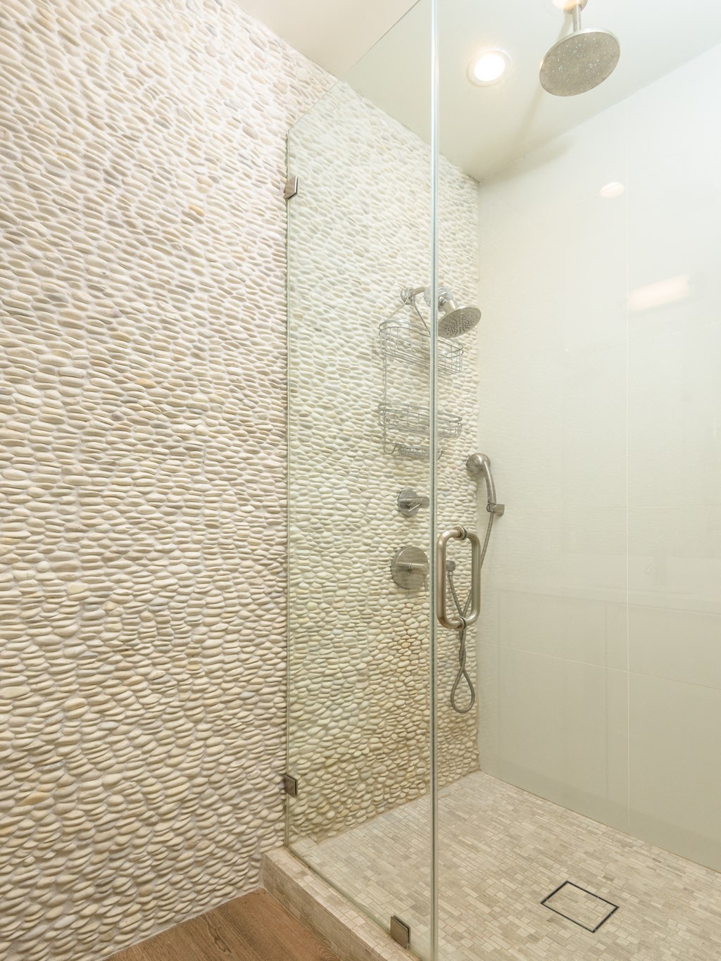 a large shower with a glass door in a bathroom