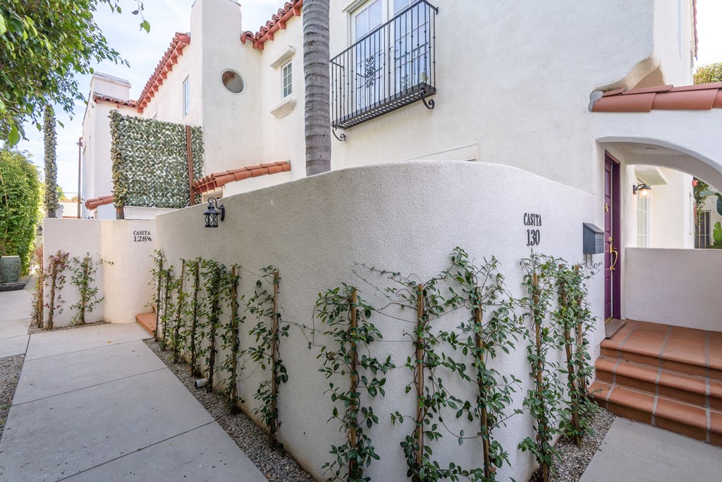 a white house with a fence and ivy on it