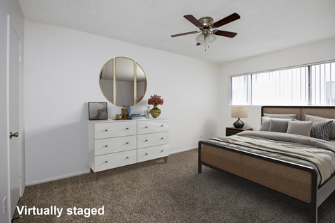 A bedroom with a bed, dresser, and mirror.