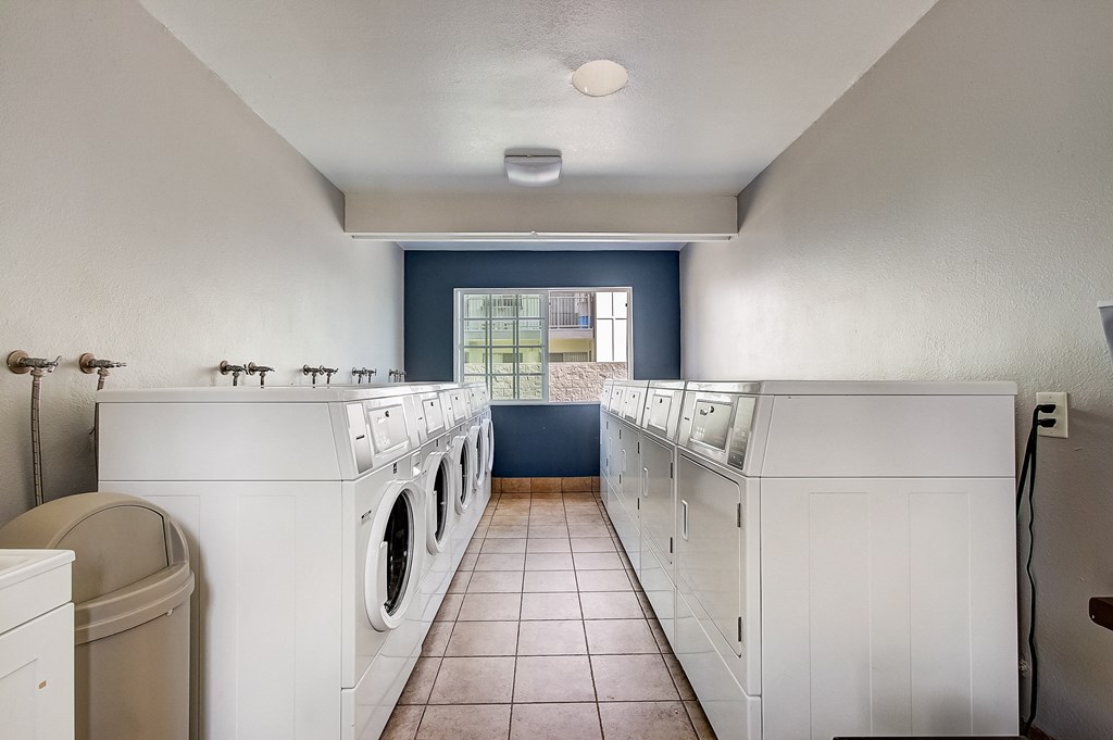 a laundry room with white washers and dryers