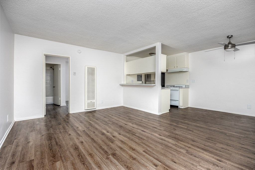 an empty living room with white walls and wood flooring