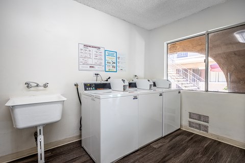 a laundry room with washing machines and a sink and a window
