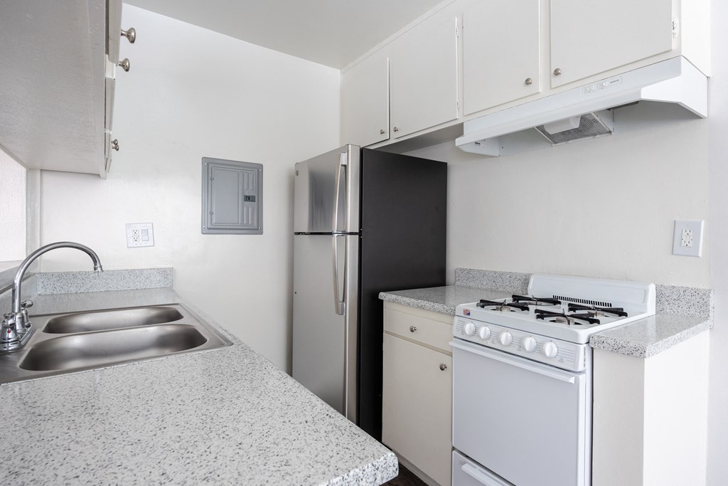 an empty kitchen with a stove refrigerator and sink