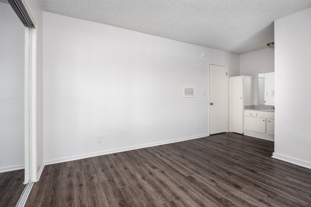 an empty living room with white walls and wood flooring
