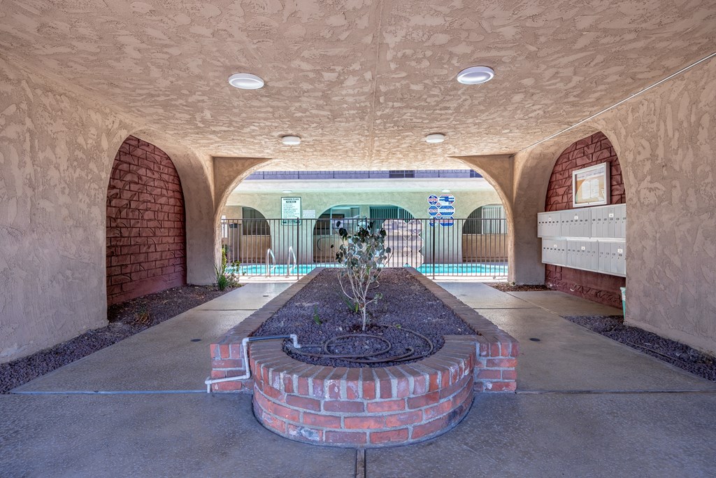 a courtyard with a fire place and a pool in the background