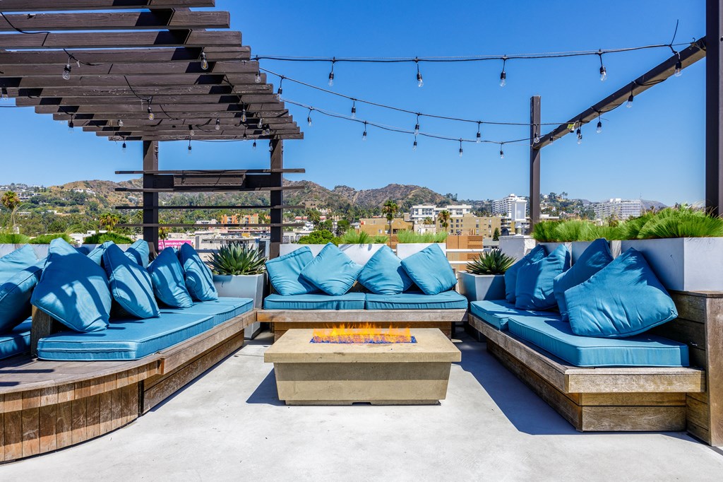 an outdoor patio with blue couches and a fire pit