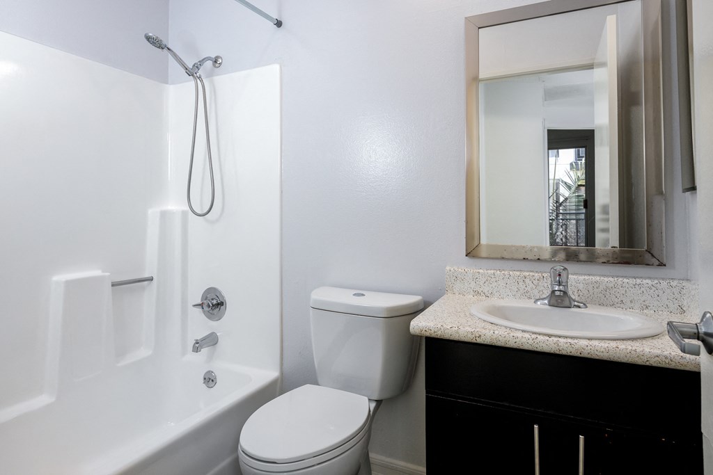 a bathroom with a toilet sink and shower and a mirror