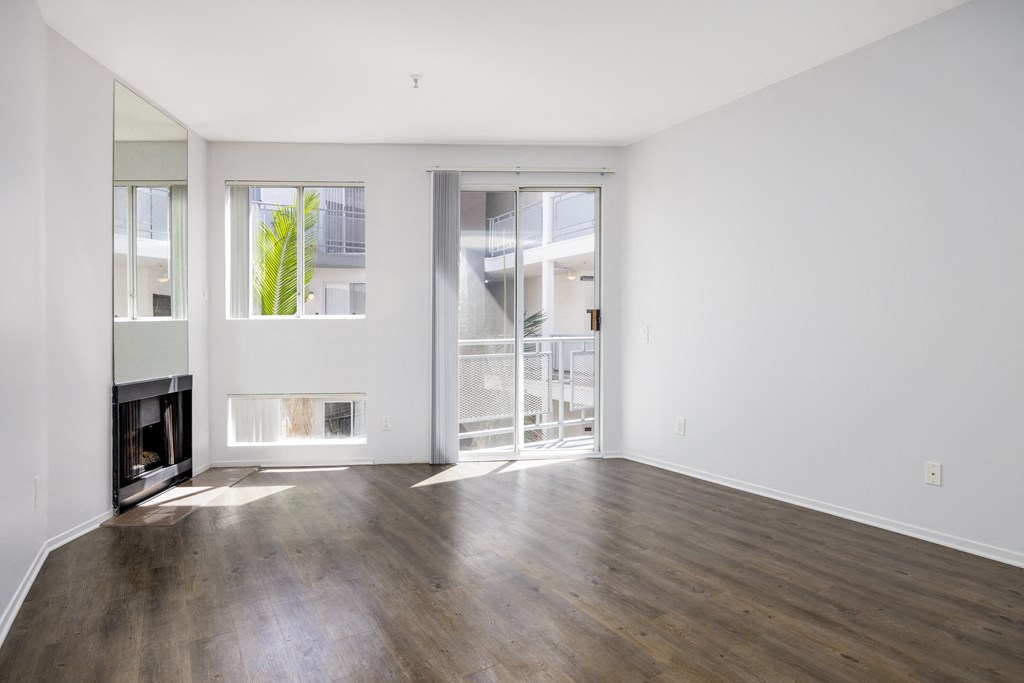 an empty living room with a fireplace and sliding glass doors