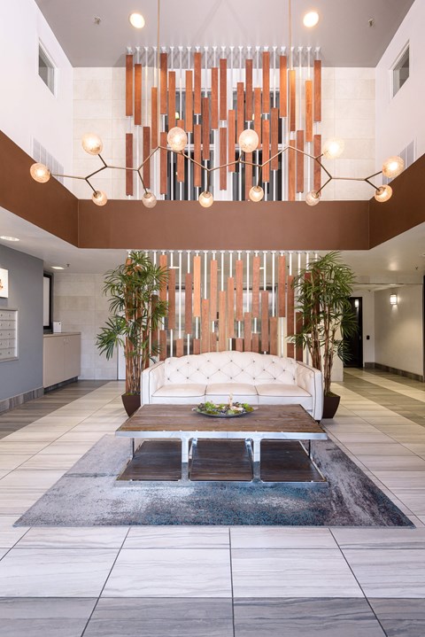 a living room with a large white couch and a chandelier