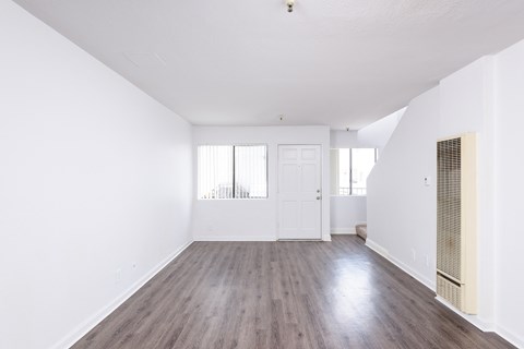 an empty living room with white walls and wood floors