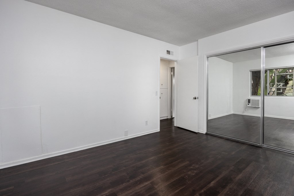 an empty living room with white walls and a sliding glass door