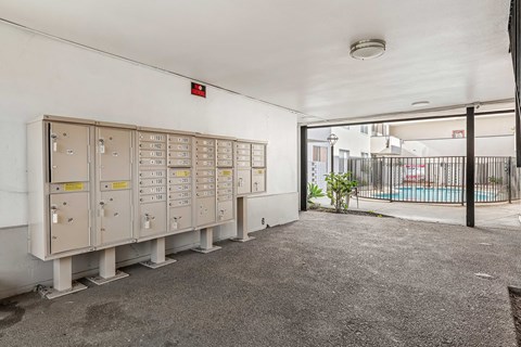 A room with a pool in the background and electrical boxes on the wall.