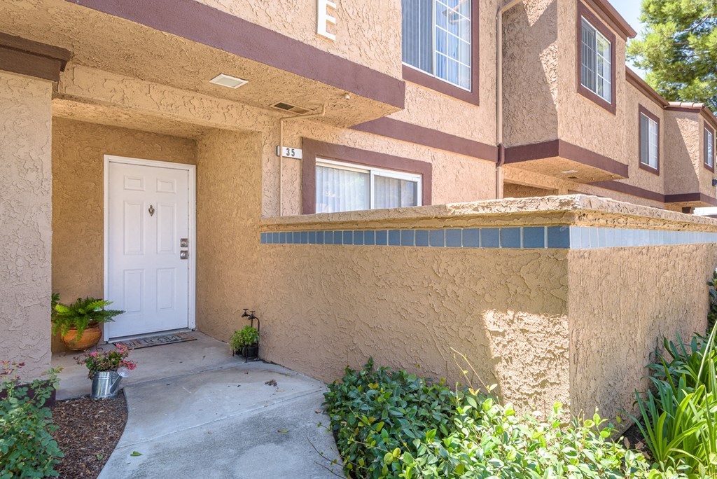 the front entrance of an apartment building with a white door