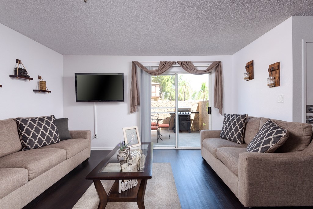 a living room with couches and a coffee table and a tv