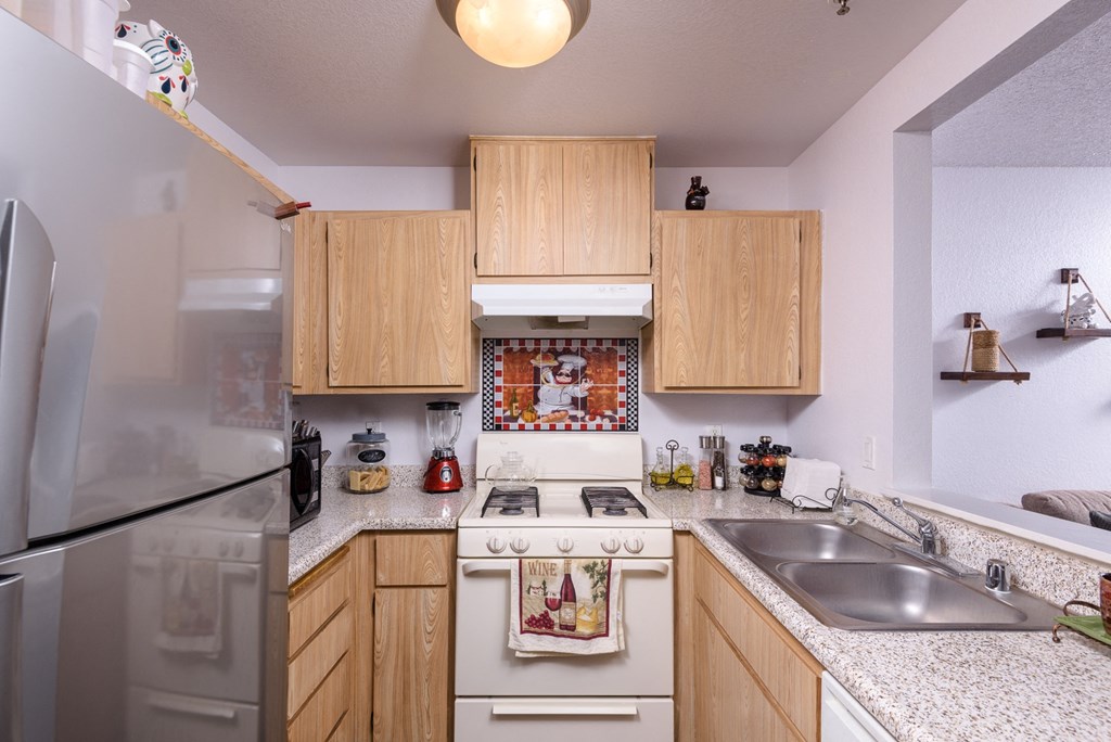 a kitchen with white appliances and wooden cabinets