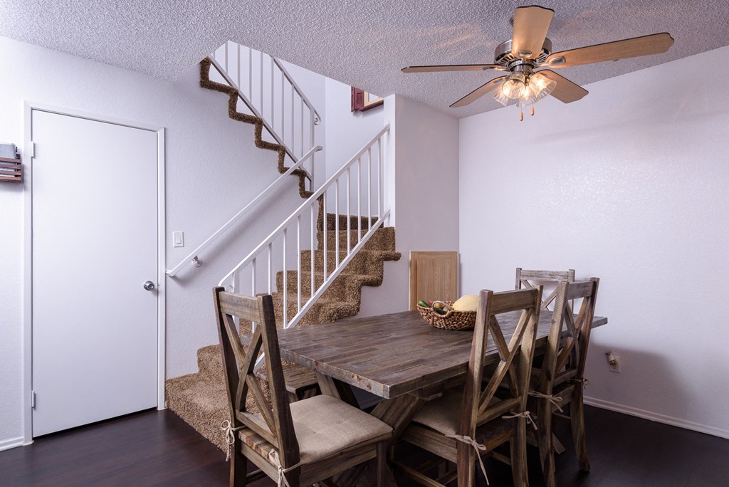 an image of a dining room with a table and chairs and a ceiling fan