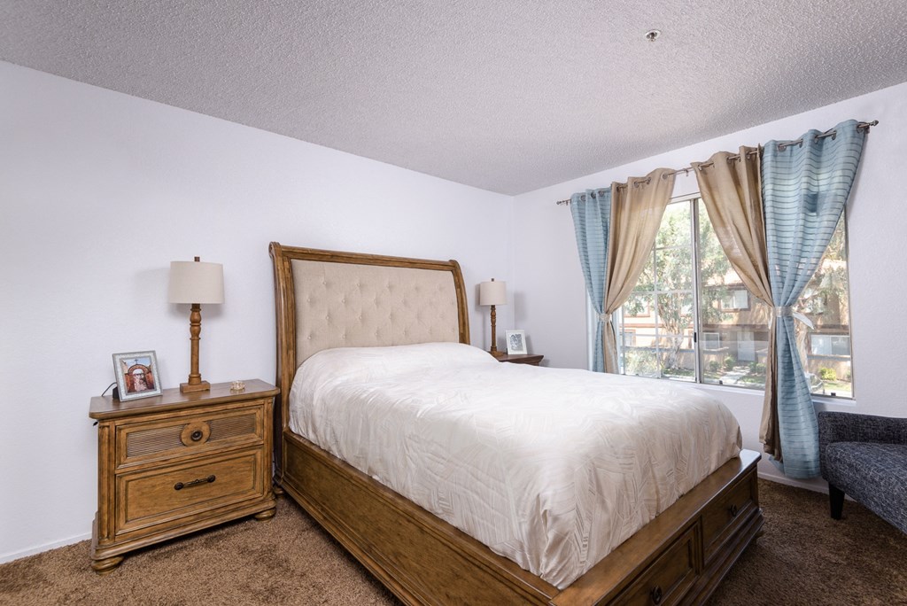 a bedroom with a bed and a dresser and a window