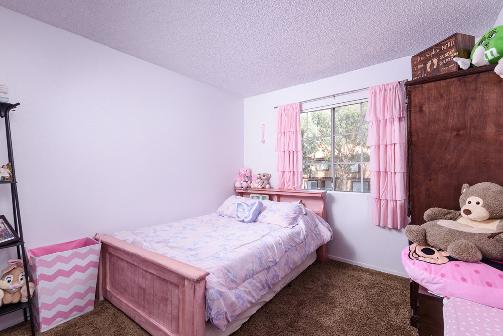 a bedroom with a bed and a dresser and a window