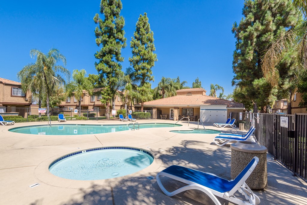 our apartments have a swimming pool with chairs and trees