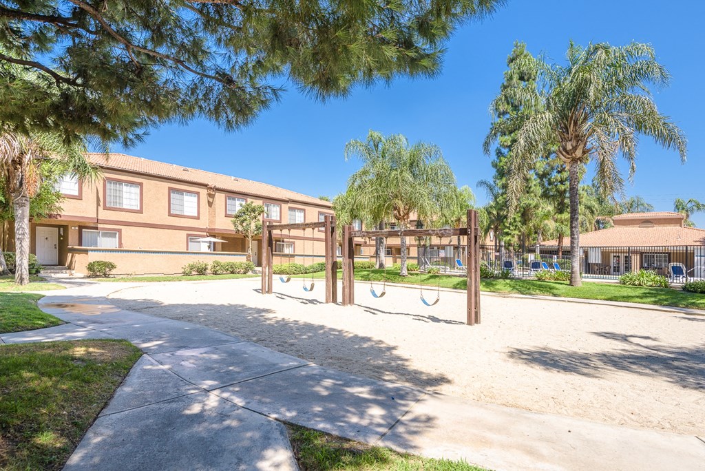 a playground in front of a building with palm trees