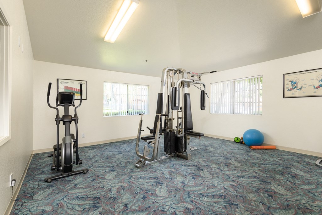 a gym with exercise equipment in the corner of a room