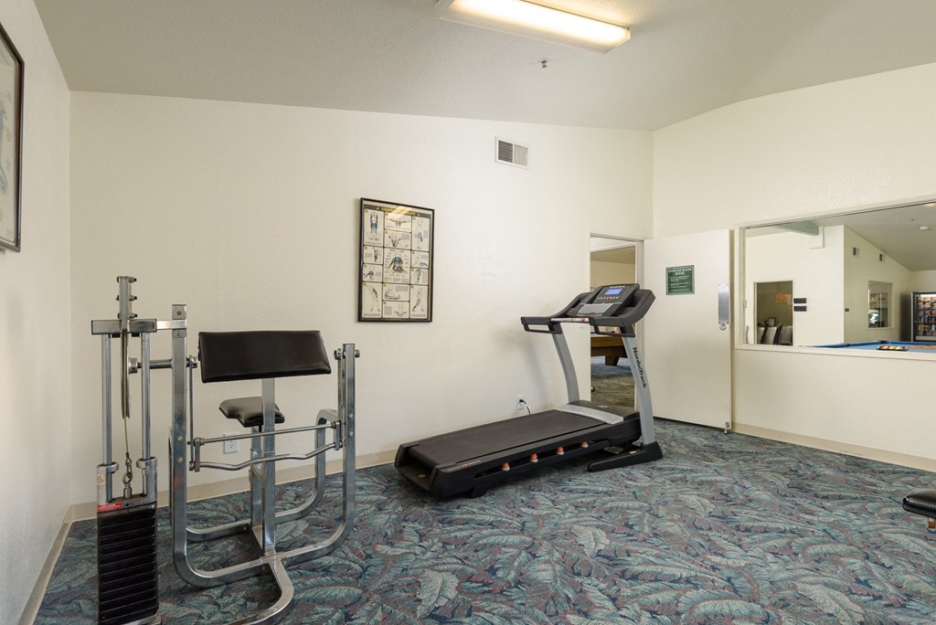 a gym with a treadmill and exercise equipment in a room