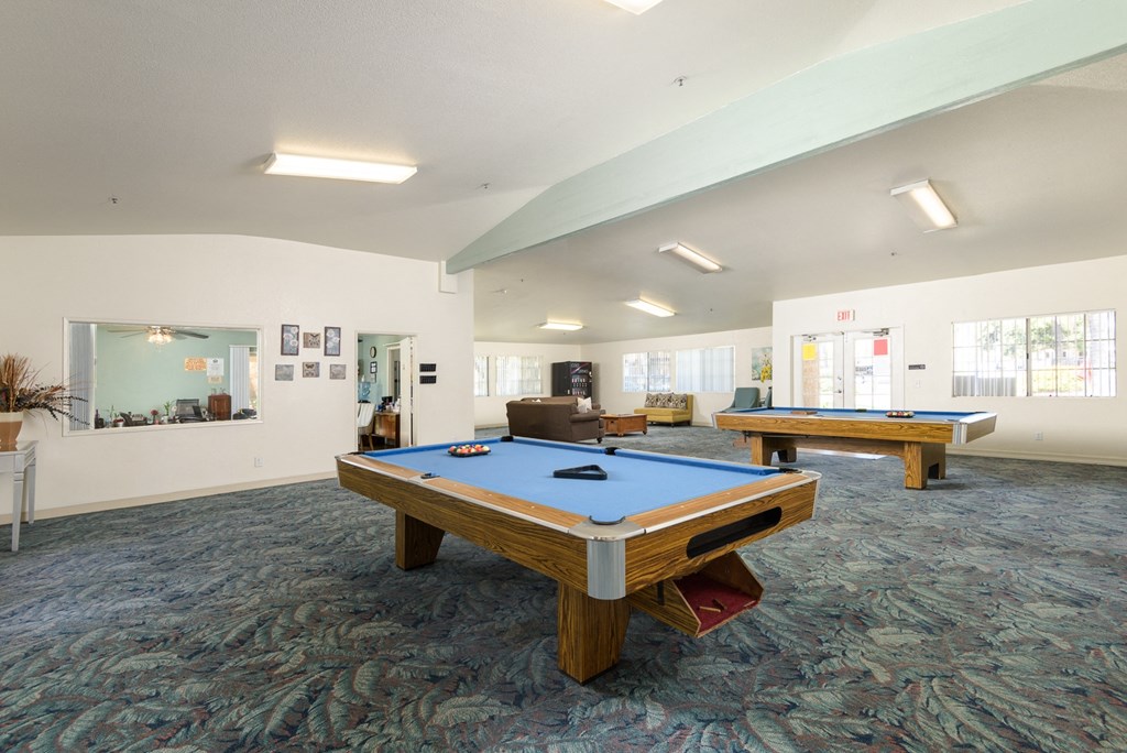 two pool tables in a community room with other amenities