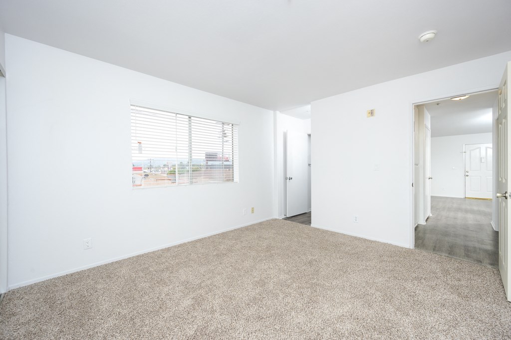 an empty living room with white walls and a window