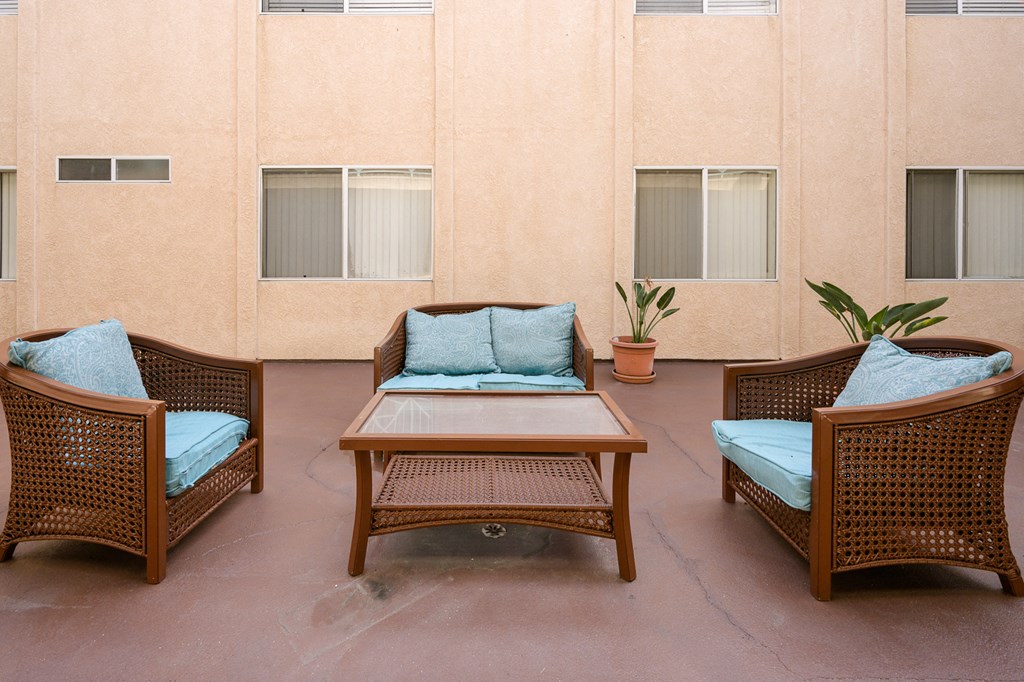 a patio with three chairs and a table