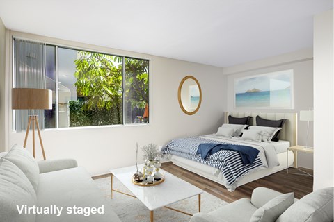 A modern bedroom with a large bed and a view of the outdoors.