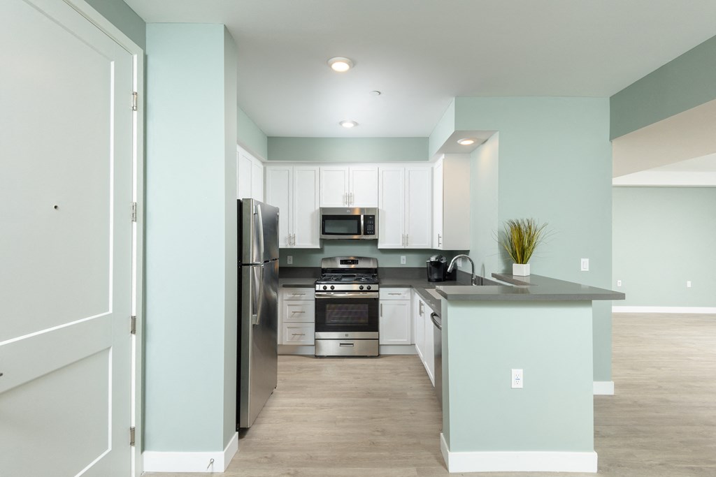 a kitchen with white cabinets and stainless steel appliances