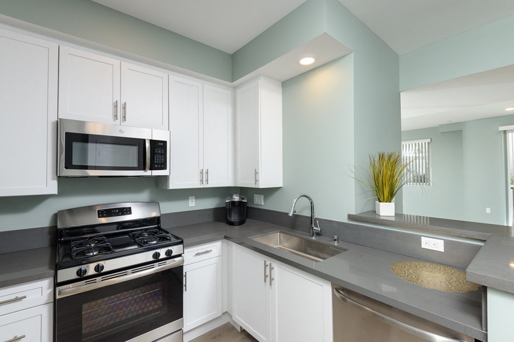 a kitchen with stainless steel appliances and white cabinets
