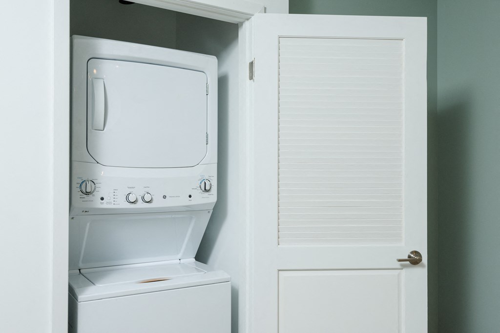 a white washer and dryer in a closet next to a door