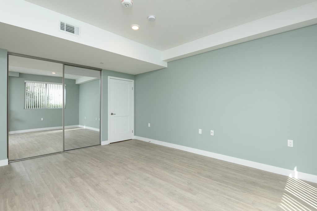 an empty room with a sliding glass door and a hard wood floor