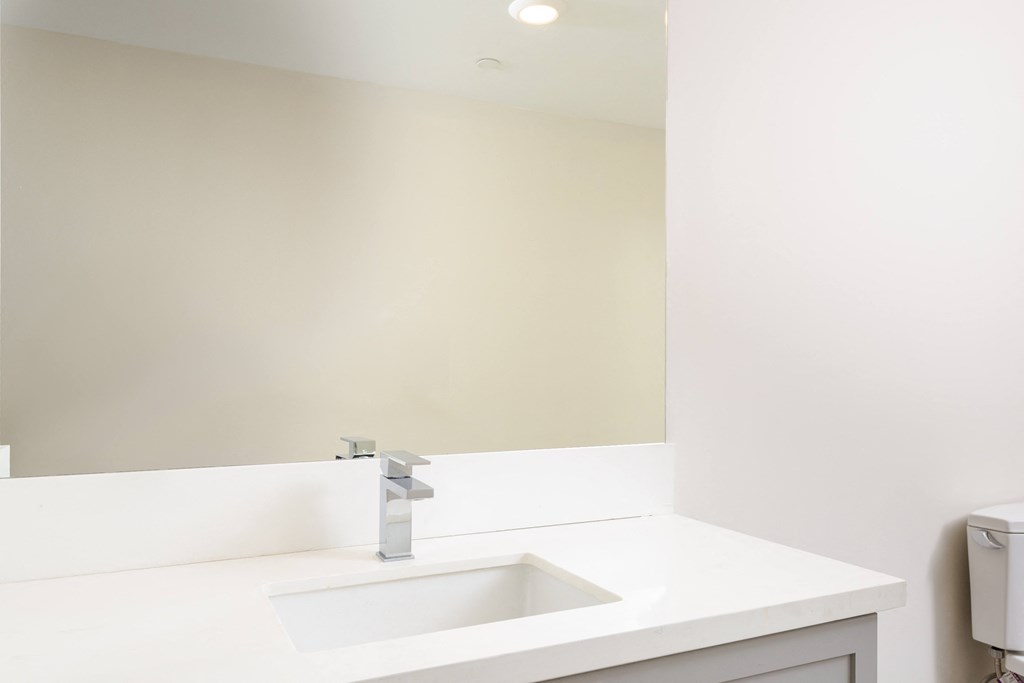 a white bathroom with a sink and a mirror