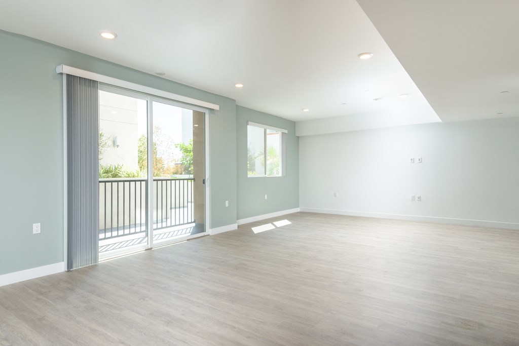 an empty living room with sliding glass doors to a balcony