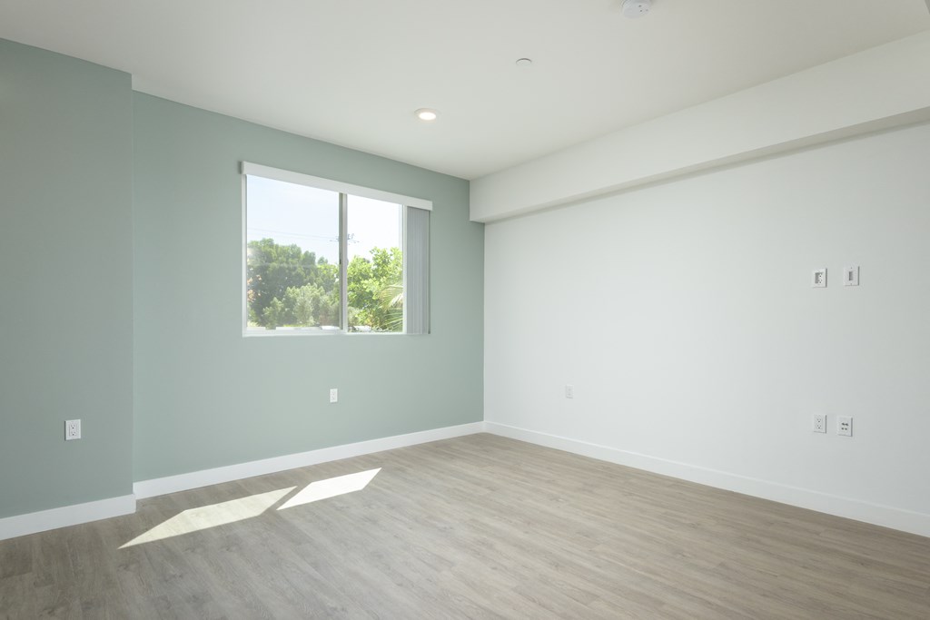 an empty room with white walls and a window