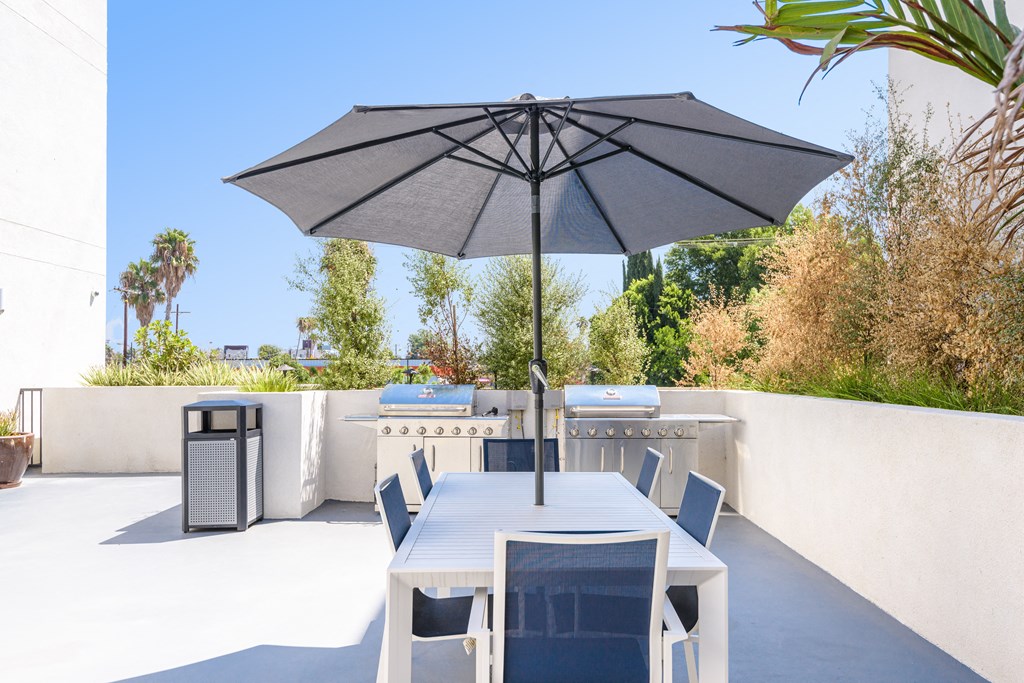 a patio with a table and chairs and an umbrella