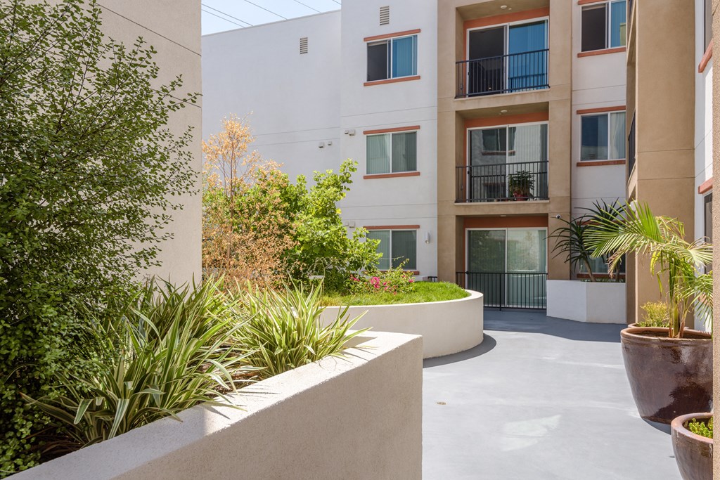 the courtyard atrium of an apartment building with plants and trees