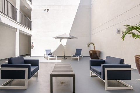 a lounge area with blue chairs and a coffee table