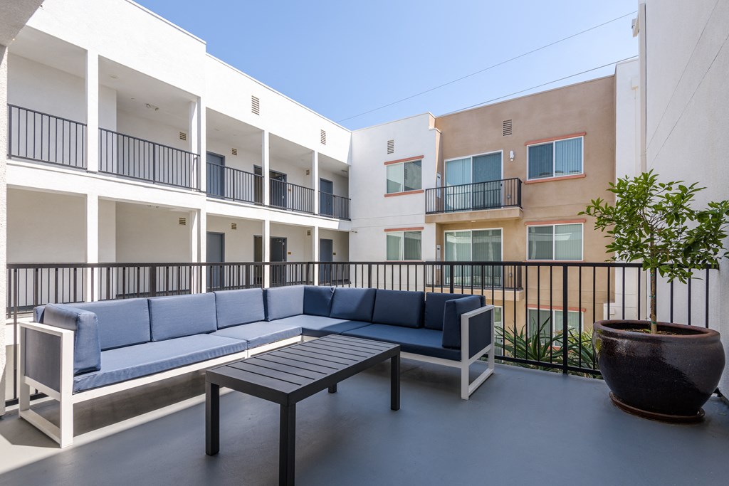 a communal area with couches and a coffee table in front of apartments