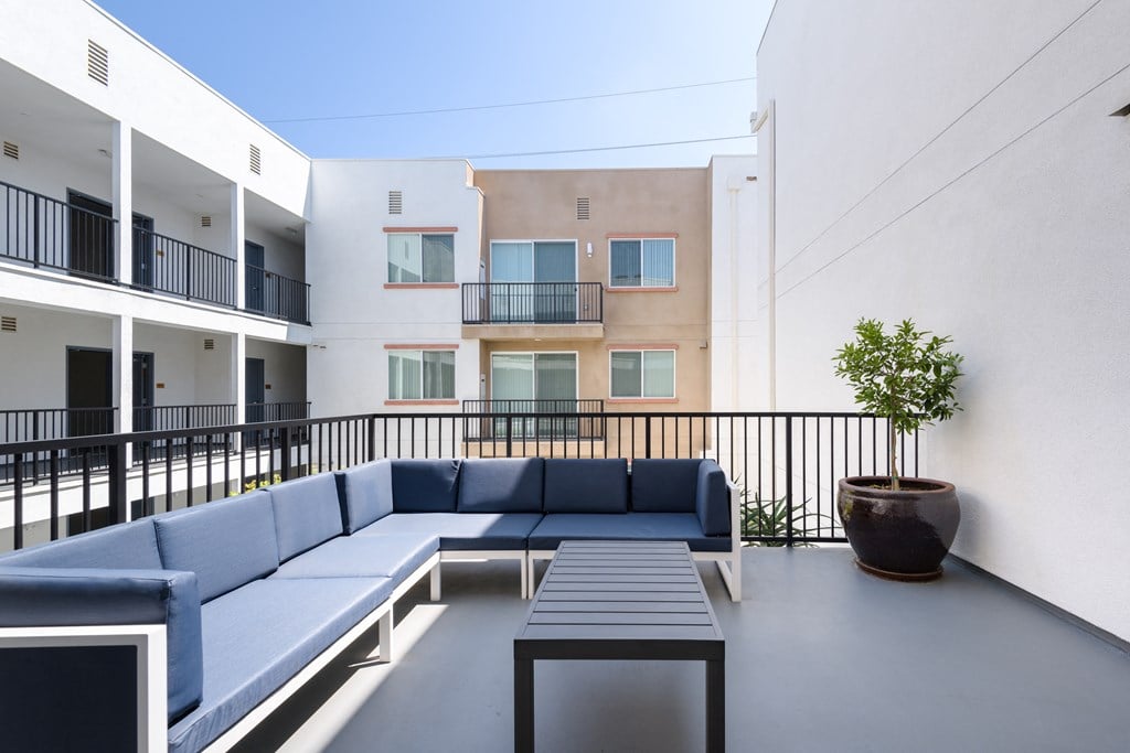a lounge area with blue couches and a wooden table