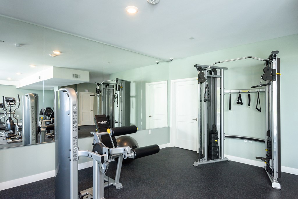 a gym with exercise equipment and mirrors in a home